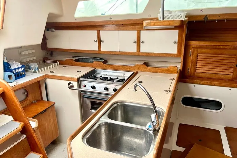 Slide: The Image of 1998 Catalina 36 MkII yacht kitchen with stove, sink, and wooden cabinetry. - 42