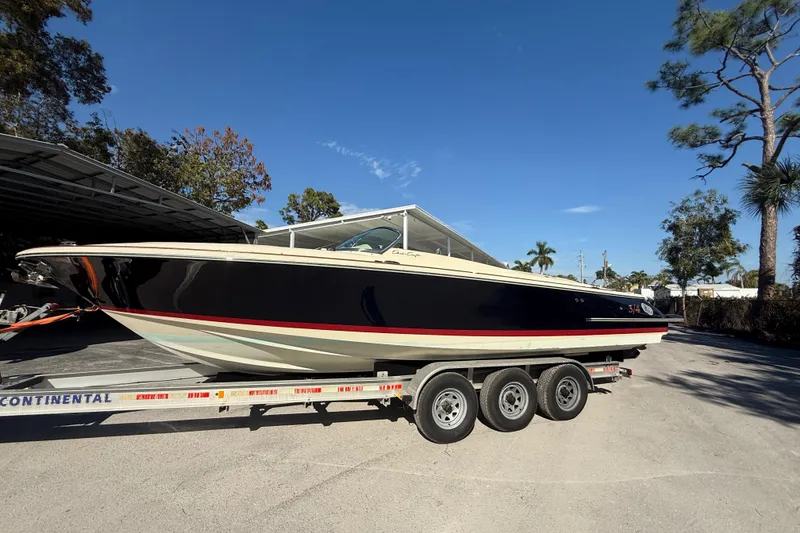 The Image of 2018 Chris-Craft Launch 30 boat on trailer, parked outdoors under clear blue sky. - 1