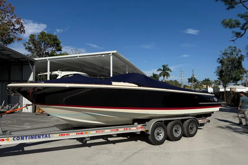 Slide: The Image of 2018 Chris-Craft Launch 30 boat on trailer, parked outdoors under clear blue sky. - 5