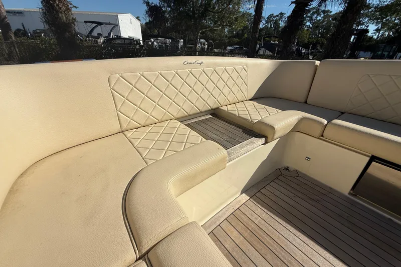 Slide: The Image of 2018 Chris-Craft Launch 30 boat interior with beige quilted seating and wooden flooring. - 9