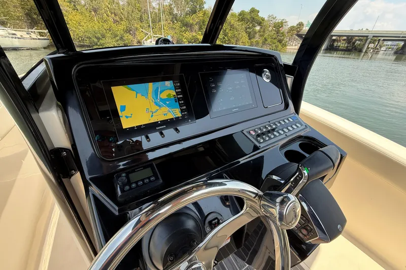 Slide: The Image of 2025 Scout 277 LXF boat dashboard with navigation screens and steering wheel. - 12