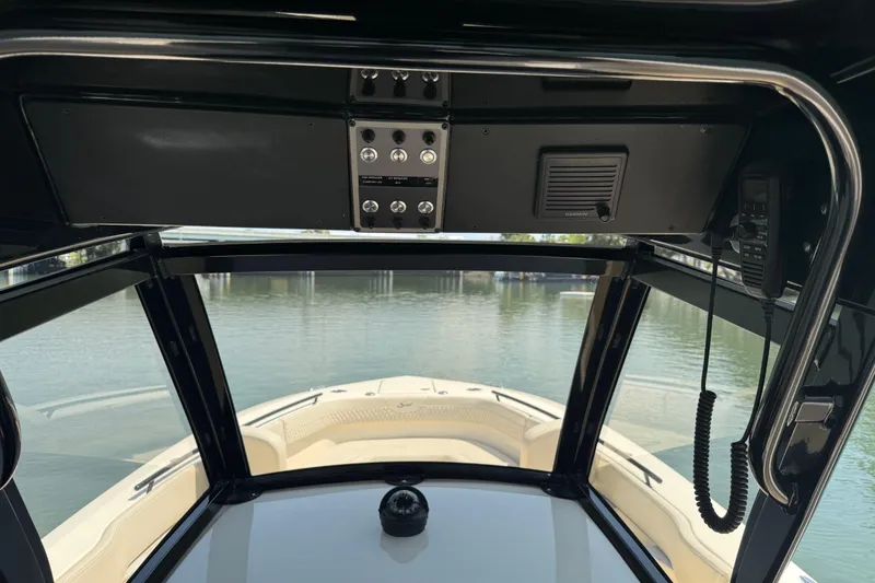 Slide: The Image of Interior view of 2025 Scout 277 LXF boat cockpit with water in background. - 14