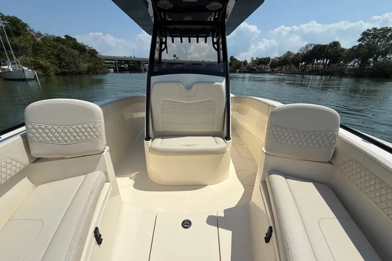 Slide: The Image of 2025 Scout 277 LXF boat interior with luxurious seating on a sunny day. - 15