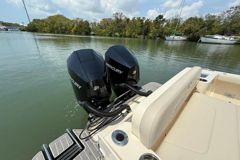 Slide: The Image of 2025 Scout 277 LXF boat with dual Mercury engines on calm water. - 7