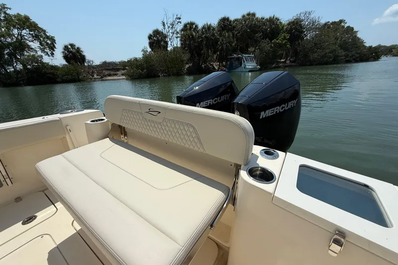 Slide: The Image of 2025 Scout 277 LXF boat with dual Mercury engines on a calm waterway. - 8