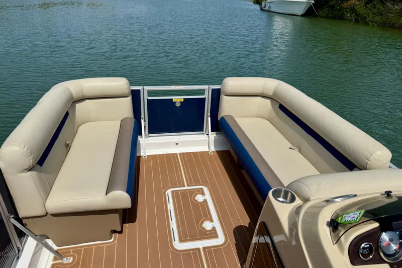 Slide: The Image of 2022 Hurricane FunDeck 2260 REF boat interior with beige seating and wood-style flooring. - 10