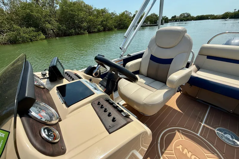 Slide: The Image of 2022 Hurricane FunDeck 2260 REF boat interior with steering wheel and comfortable seating. - 14