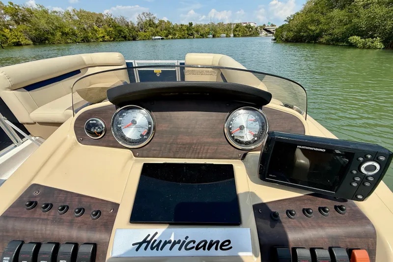 Slide: The Image of Dashboard view of a 2022 Hurricane FunDeck 2260 REF boat on a scenic waterway. - 16