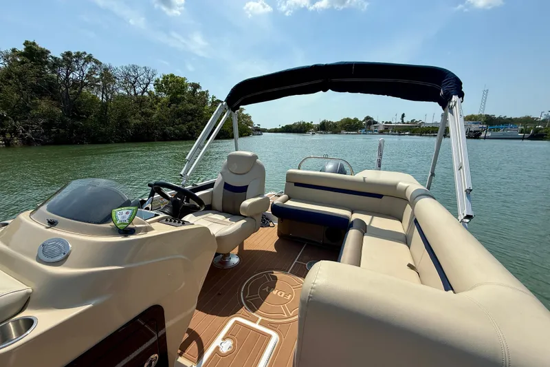 Slide: The Image of 2022 Hurricane FunDeck 2260 REF boat interior on a sunny day, featuring comfortable seating. - 18