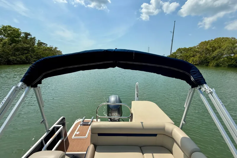 Slide: The Image of 2022 Hurricane FunDeck 2260 REF boat on calm water with canopy and outboard motor. - 20
