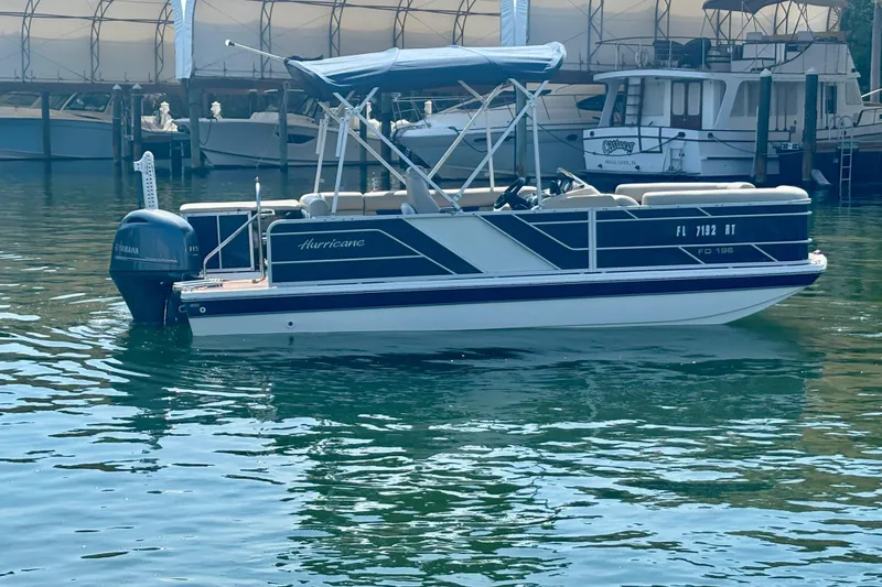 Slide: The Image of 2022 Hurricane FunDeck 2260 REF boat docked in marina, featuring Yamaha outboard motor. - 8
