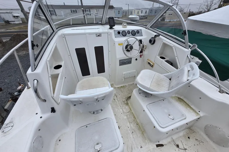 Slide: The Image of 2005 Sea Fox 210 Walk Around boat interior with steering wheel and seating. - 1