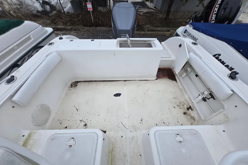 Slide: The Image of 2005 Sea Fox 210 Walk Around boat interior with storage compartments and seating. - 2