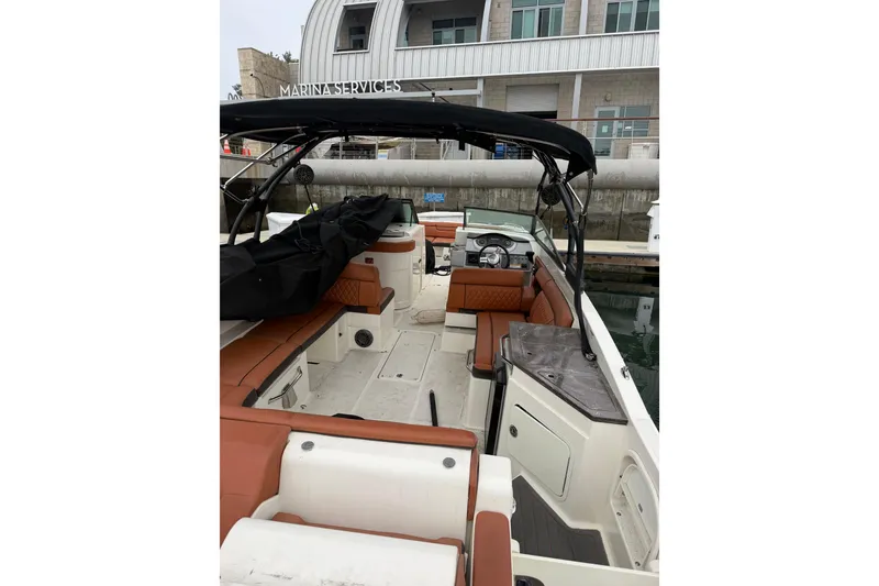 Slide: The Image of 2017 Sea Ray SDX 290 boat docked at marina, featuring spacious seating and sleek design. - 10