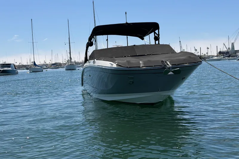 Slide: The Image of 2017 Sea Ray SDX 290 boat anchored in a marina with sailboats in the background. - 11