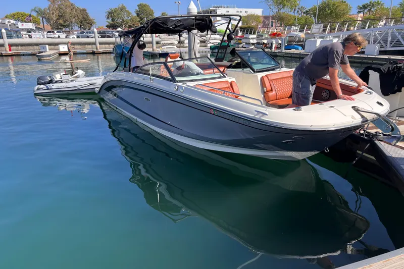 Slide: The Image of 2017 Sea Ray SDX 290 boat docked at marina with person onboard. - 2