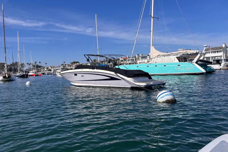 Slide: The Image of 2017 Sea Ray SDX 290 boat moored in a marina with sailboats and clear blue sky. - 3