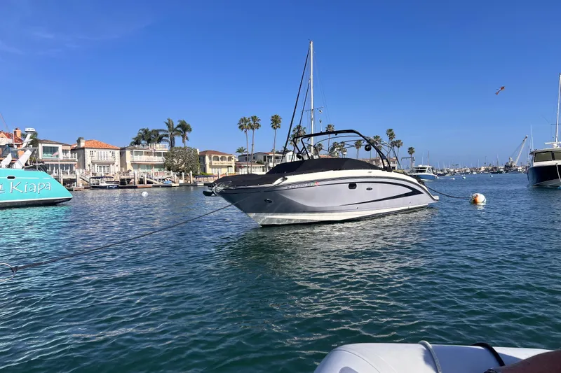 Slide: The Image of 2017 Sea Ray SDX 290 boat anchored in a scenic marina with palm trees. - 4
