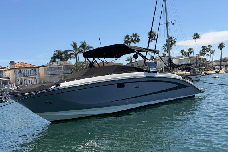 Slide: The Image of 2017 Sea Ray SDX 290 boat docked, with "For Sale" sign, in sunny marina. - 6
