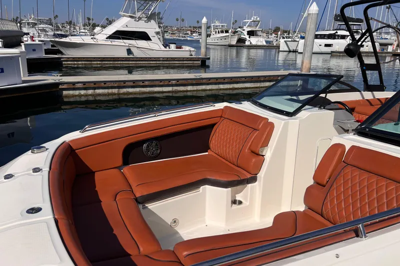 Slide: The Image of 2017 Sea Ray SDX 290 boat with luxurious brown seating at a marina. - 7