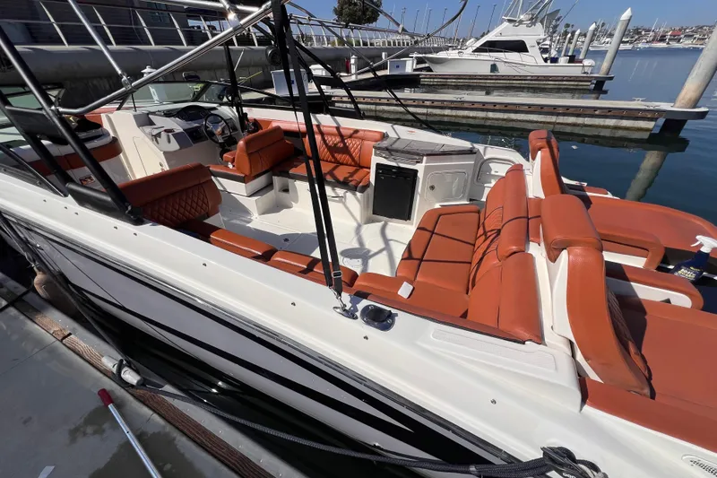 Slide: The Image of 2017 Sea Ray SDX 290 boat with orange seating, docked at a marina. - 8