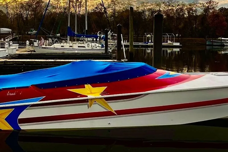 The Image of 2002 Avanti 42sp speedboat with vibrant star design docked at marina. - 0