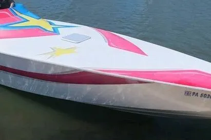 Slide: The Image of 2002 Avanti 42sp speedboat with vibrant star graphics on water. - 14