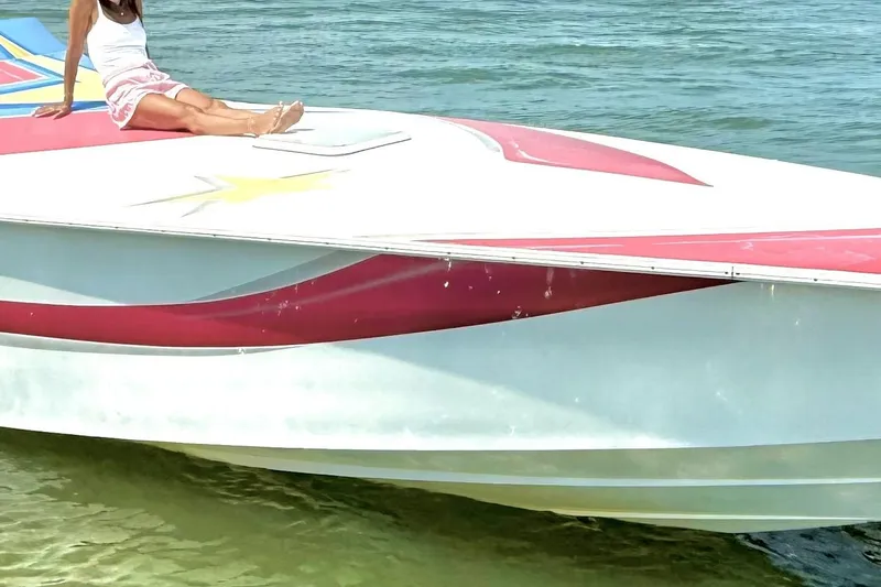 Slide: The Image of 2002 Avanti 42sp boat with red and white design on water. - 16