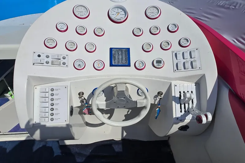 Slide: The Image of Control panel of a 2002 Avanti 41 boat with gauges and steering wheel. - 28