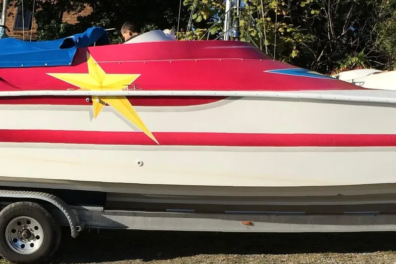 Slide: The Image of 2002 Avanti 42sp boat with red and white design, yellow star decal, on trailer. - 29