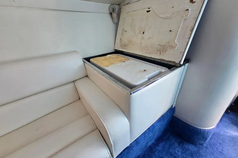 Slide: The Image of White leather seating and storage compartment in a 2002 Avanti 41 boat interior. - 46