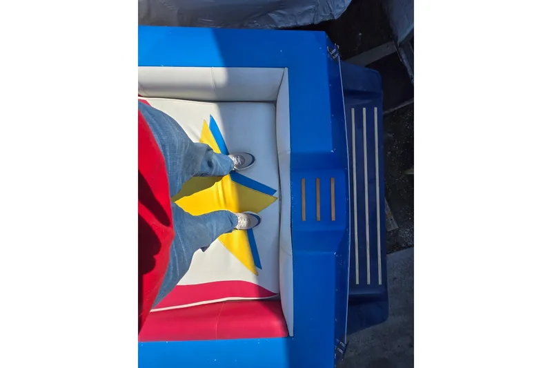 Slide: The Image of Person standing on inflatable with colorful star design, wearing jeans and sneakers. - 57