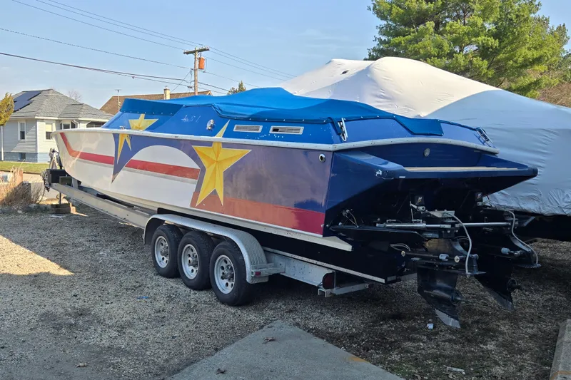 Slide: The Image of 2002 Avanti 41 boat with star graphics on a trailer, parked outdoors. - 62