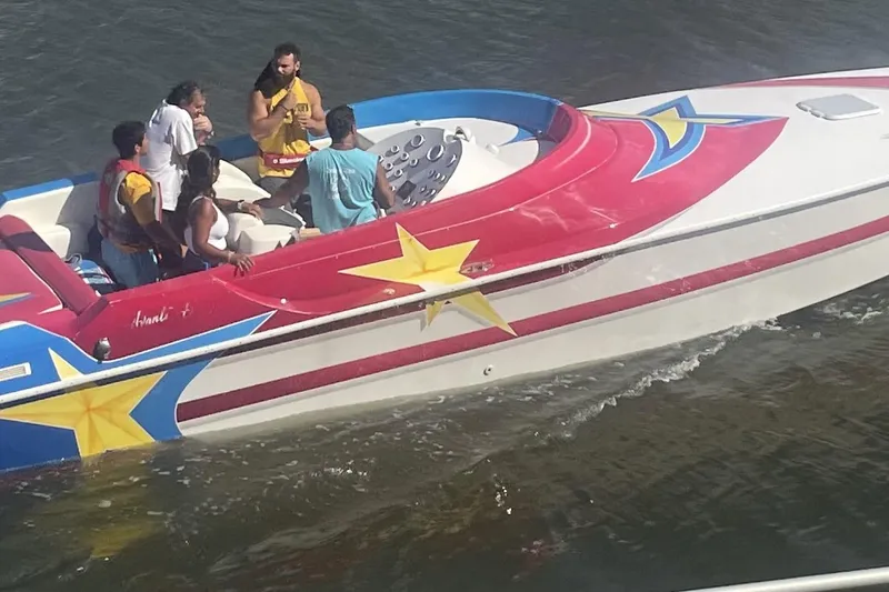 Slide: The Image of Colorful 2002 Avanti 42sp boat with star decals on water. - 8