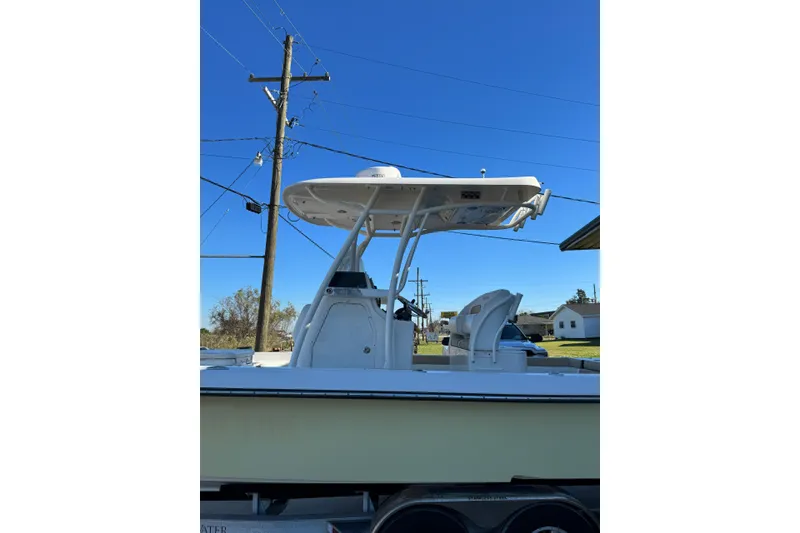 Slide: The Image of 2016 ShearWater 27 Carolina boat with T-top, parked outdoors under clear blue sky. - 5