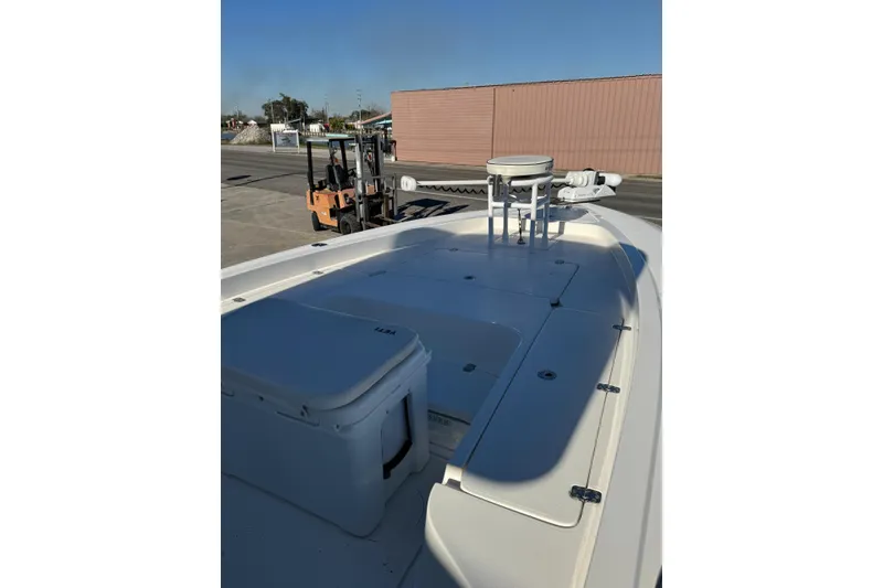 Slide: The Image of 2016 ShearWater 27 Carolina boat deck with storage and equipment, parked near a forklift. - 8