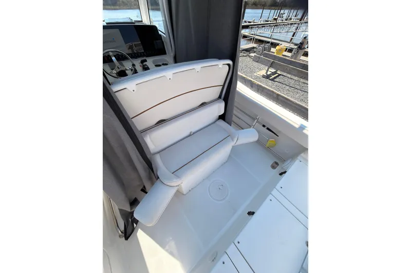 Slide: The Image of 2020 Sea Hunt Ultra 255 SE boat interior with white seating and control panel. - 16