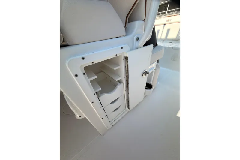 Slide: The Image of 2020 Sea Hunt Ultra 255 SE boat storage compartment with open door and shelves. - 21