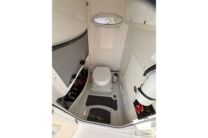 Slide: The Image of Interior of 2020 Sea Hunt Ultra 255 SE boat, featuring a compact marine toilet. - 7