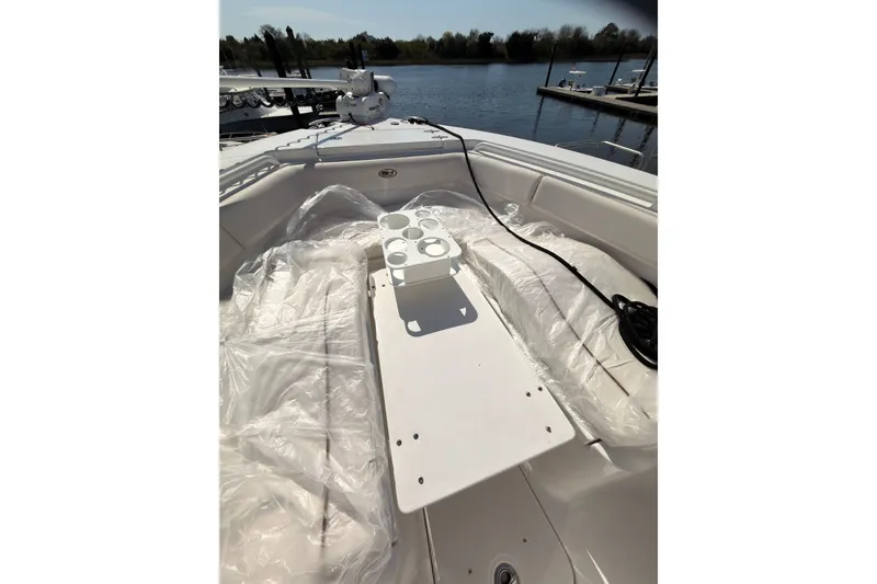 Slide: The Image of 2020 Sea Hunt Ultra 255 SE boat interior with cup holders, docked by a serene lake. - 8
