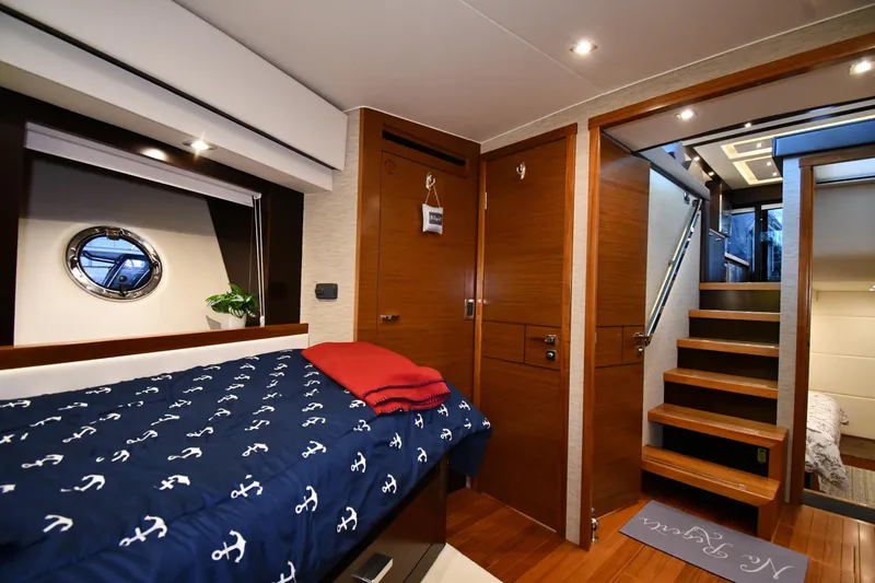 Slide: The Image of Luxurious 2016 Tiara Yachts 50 Coupe interior cabin with nautical-themed bedding. - 21