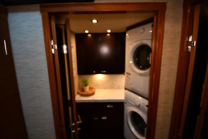 Slide: The Image of Laundry area inside 2016 Tiara Yachts 50 Coupe, featuring stacked washer and dryer. - 25