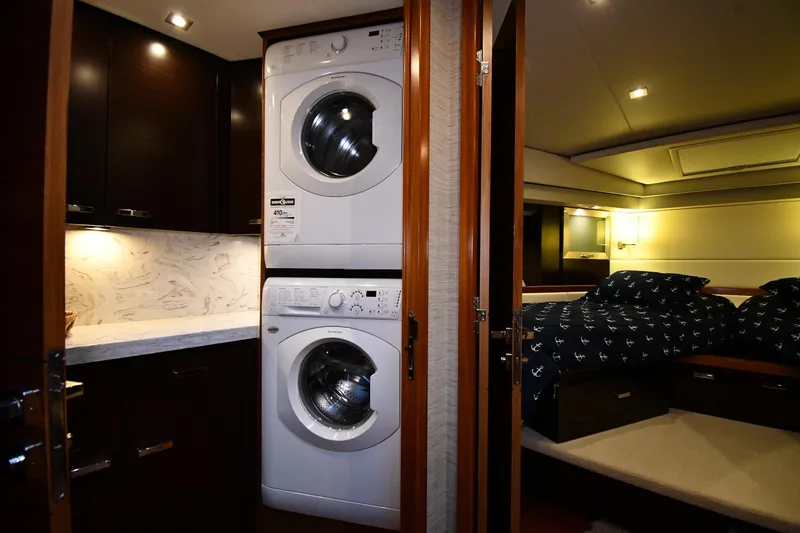 Slide: The Image of Laundry area and bedroom inside a 2016 Tiara Yachts 50 Coupe, featuring modern amenities. - 26