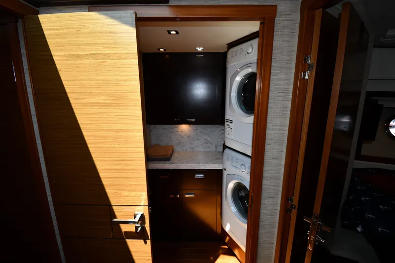Slide: The Image of Laundry area with stacked washer and dryer in 2016 Tiara Yachts 50 Coupe. - 33