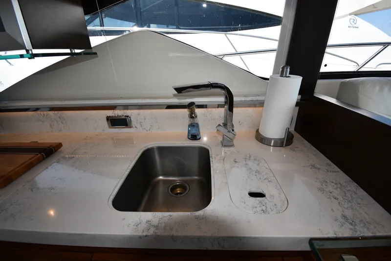 Slide: The Image of Modern kitchen sink area on 2016 Tiara Yachts 50 Coupe with marble countertop. - 46