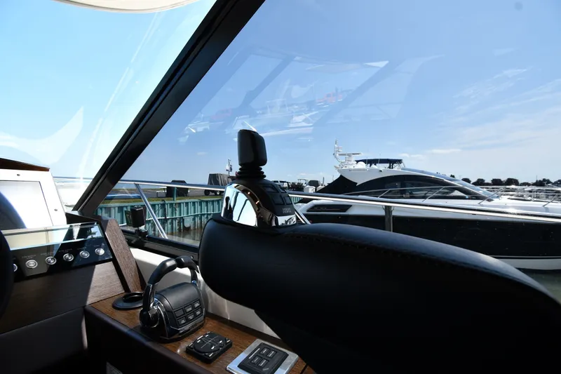 Slide: The Image of Interior view of 2016 Tiara Yachts 50 Coupe, showcasing helm and marina scenery. - 58