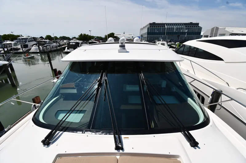 Slide: The Image of 2016 Tiara Yachts 50 Coupe docked at marina, showcasing sleek design and windshield wipers. - 8