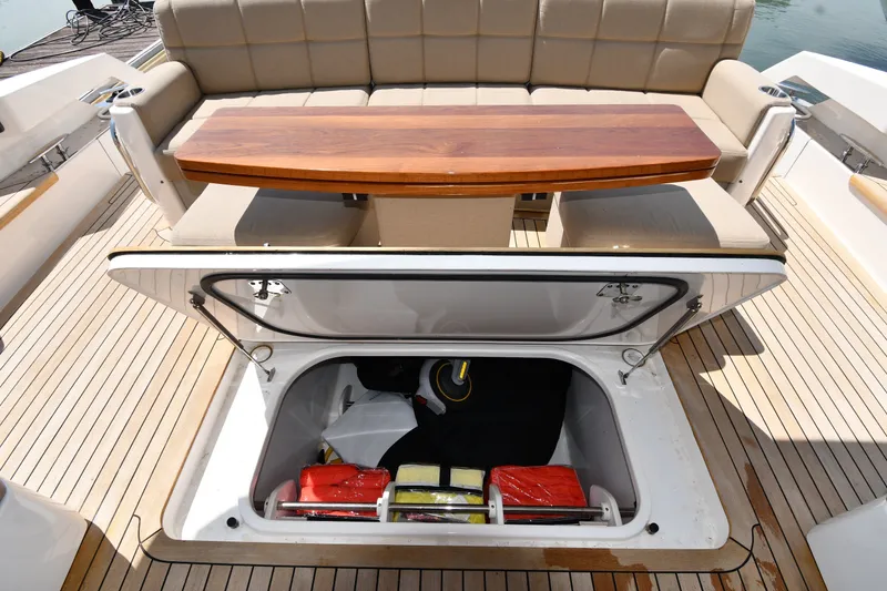 Slide: The Image of 2016 Tiara Yachts 50 Coupe deck with open storage compartment and seating area. - 21