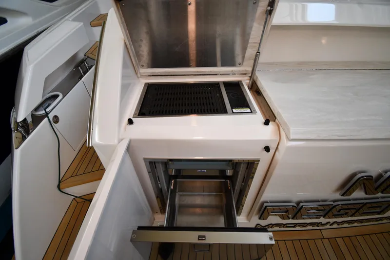 Slide: The Image of Outdoor kitchen area on a 2016 Tiara Yachts 50 Coupe with grill and storage. - 56