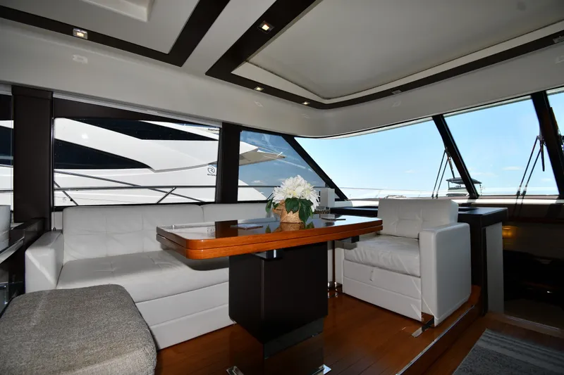 Slide: The Image of Luxurious interior of 2016 Tiara Yachts 50 Coupe with white seating and wooden table. - 52